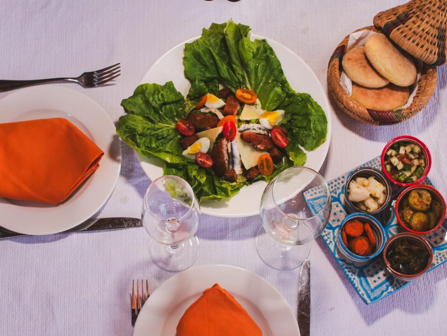 A table topped with plates of food and glasses of wine