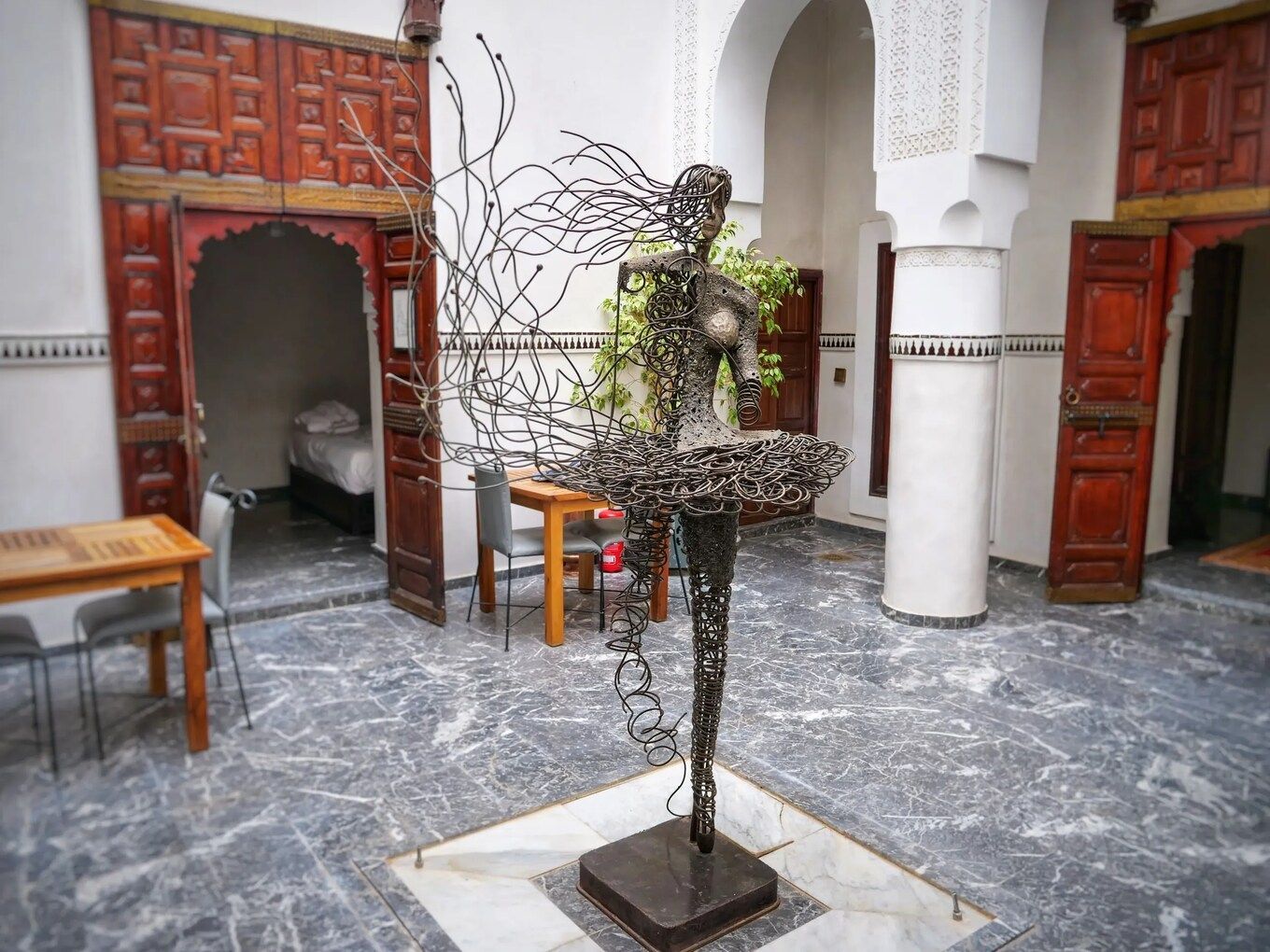 A statue of a woman is in the middle of a courtyard.