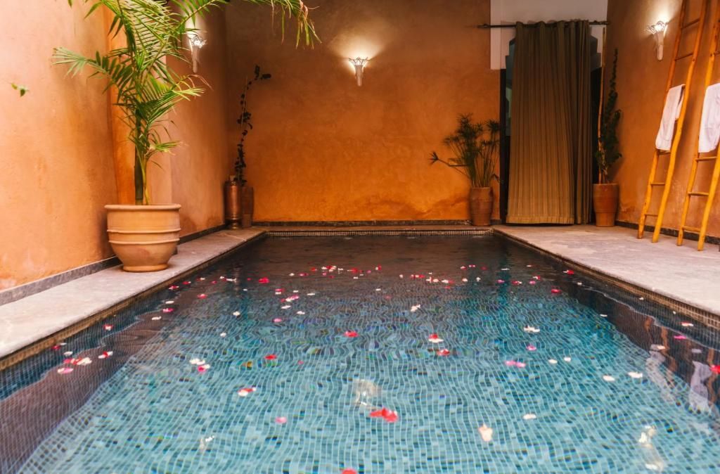 A large indoor swimming pool filled with water and petals.