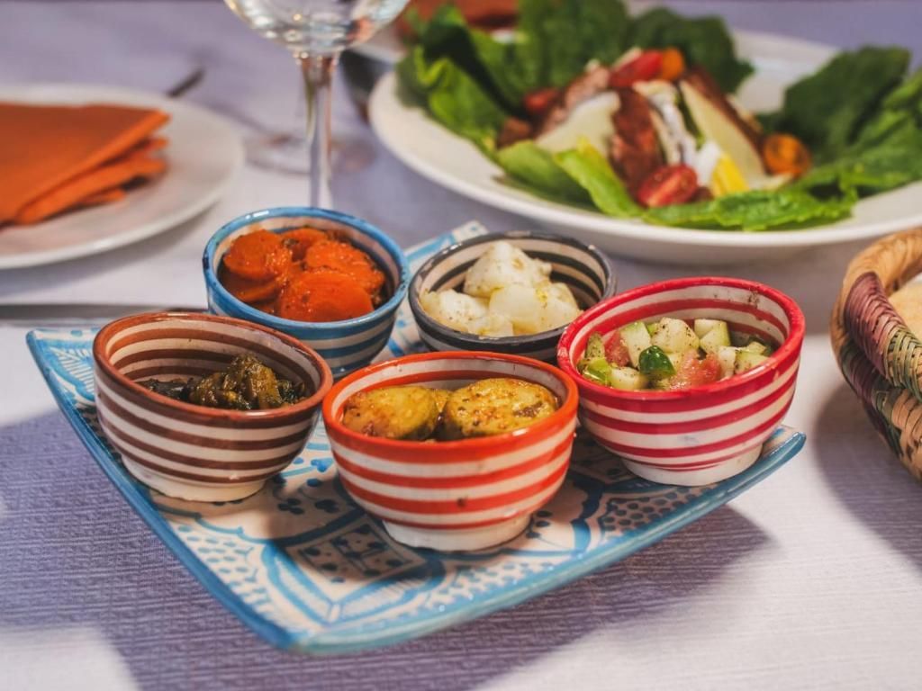A tray of small bowls filled with different types of food on a table.