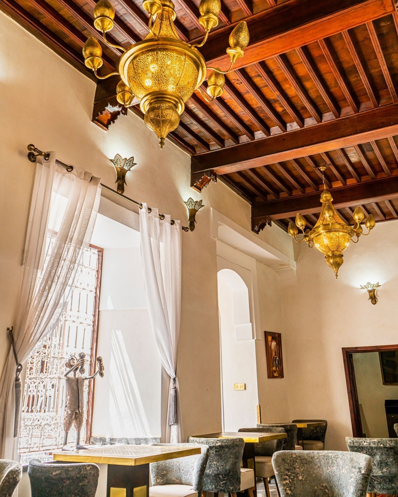 A room with tables and chairs and a wooden ceiling