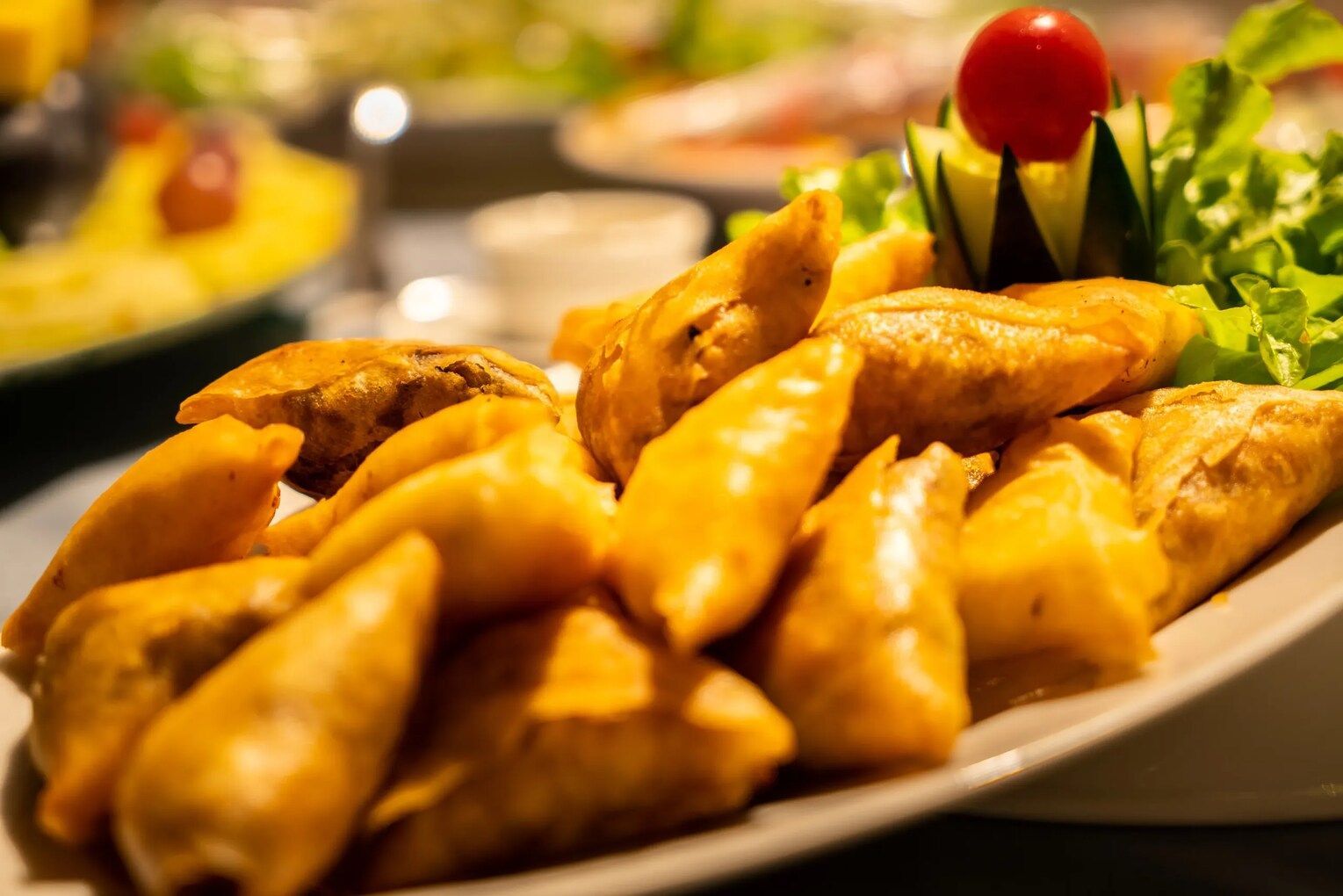 A close up of a plate of food with a cherry tomato on top.