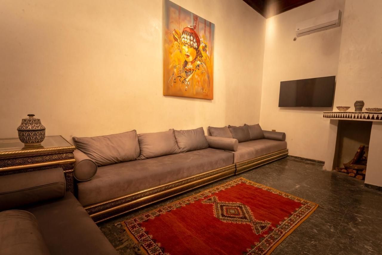 A living room with a couch , rug , television and fireplace.