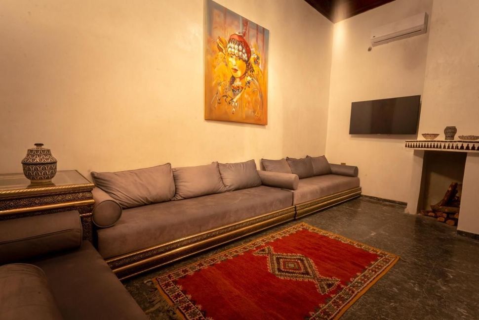 A living room with a couch , rug , television and fireplace.