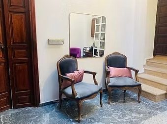 A room with two chairs and a mirror on the wall.