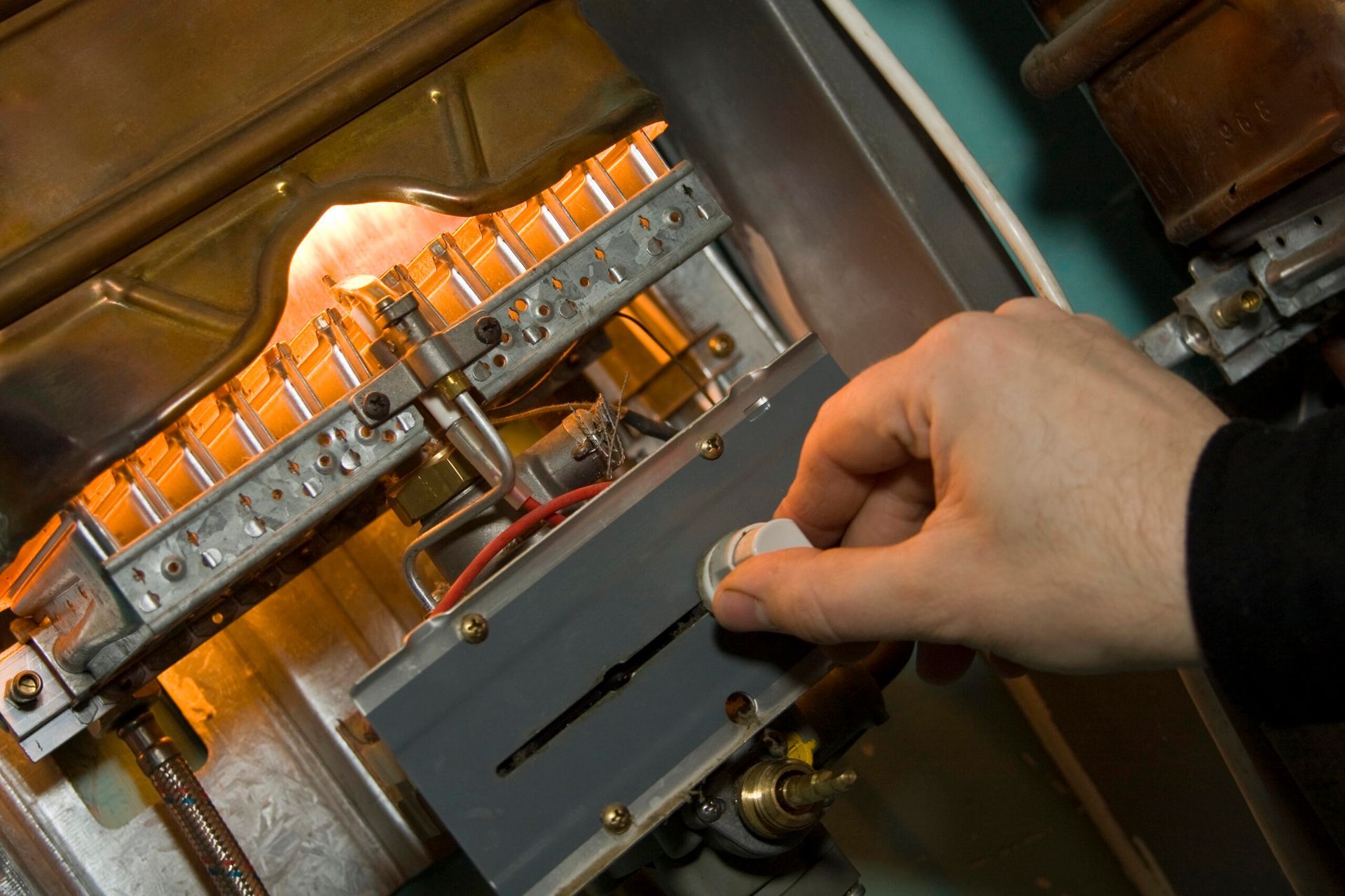 Hand turning a dial on a machine with glowing orange lights.