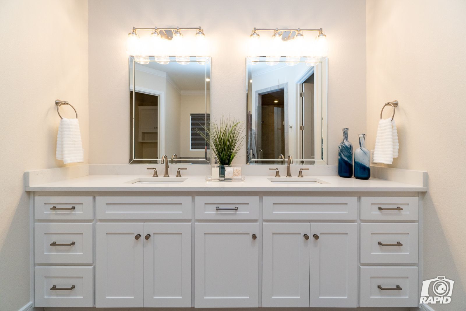 A bathroom with a double sink and two mirrors