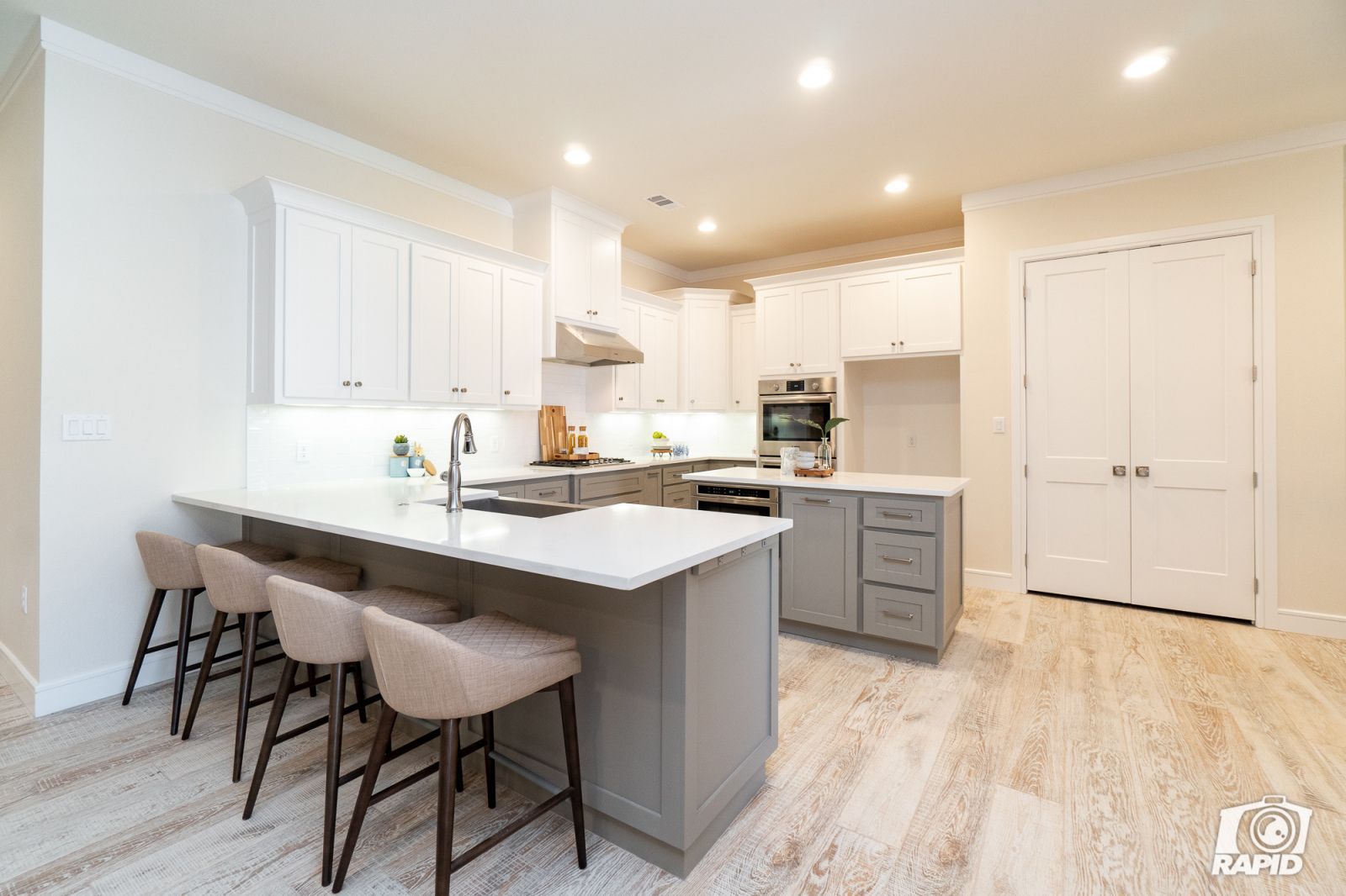 A kitchen with white cabinets and a large island