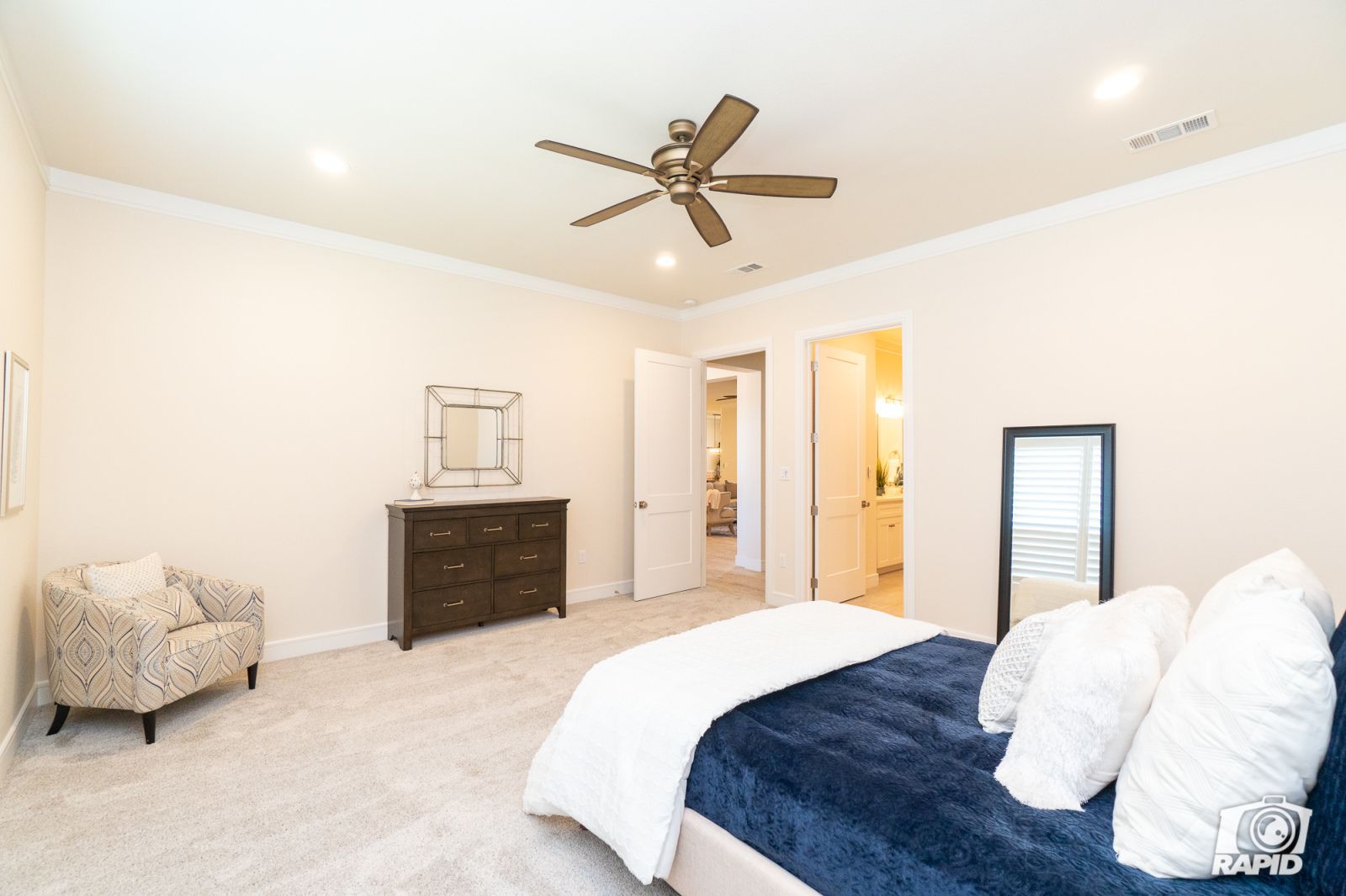 A bedroom with a large bed and a ceiling fan