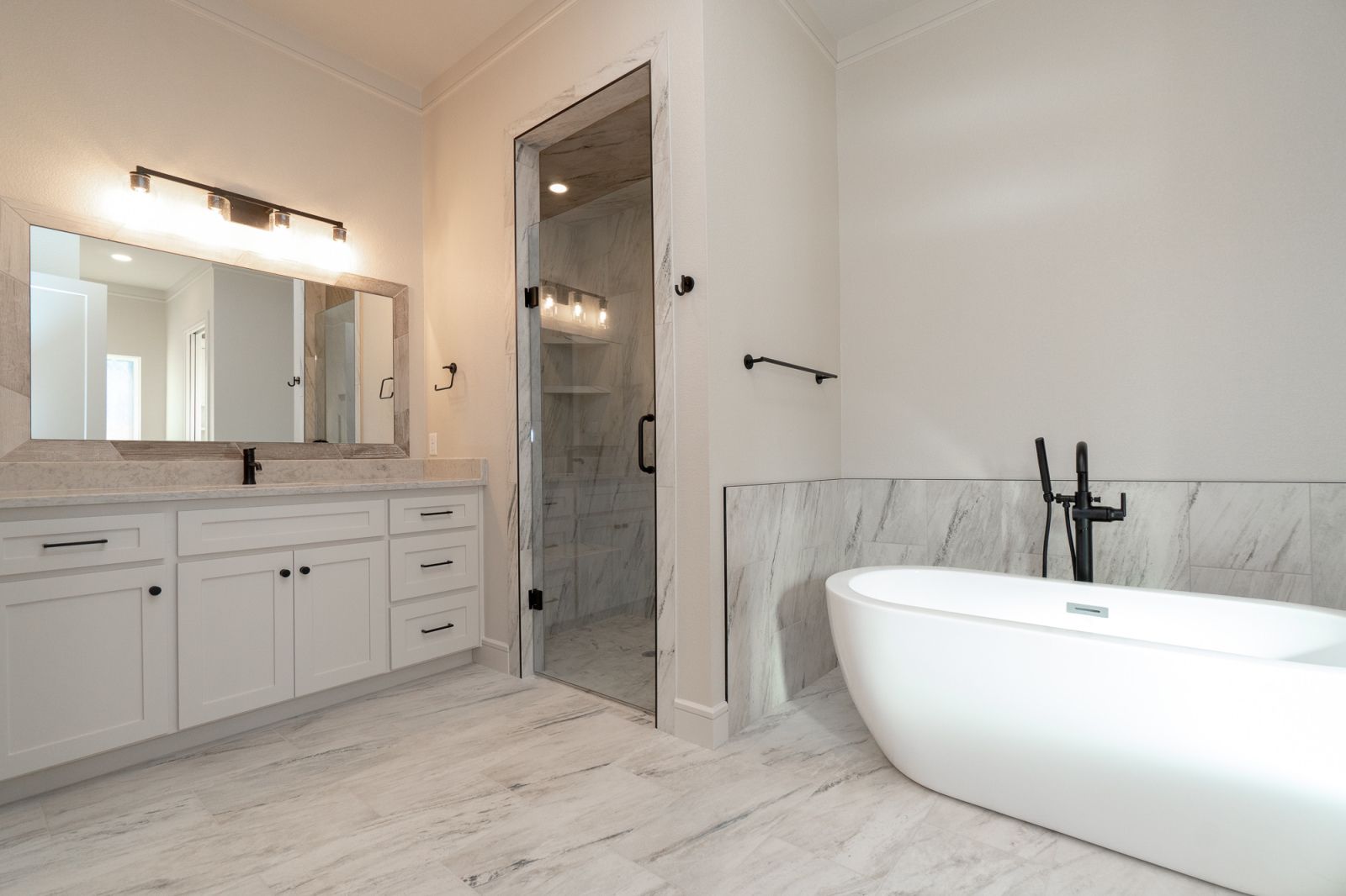 A bathroom with two sinks , a tub and a shower.