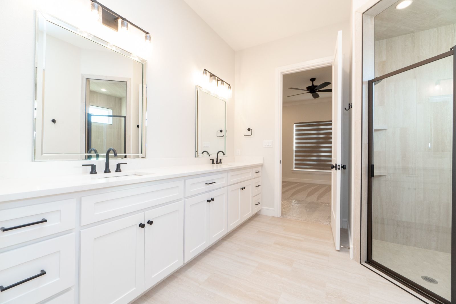 A bathroom with two sinks and a walk in shower