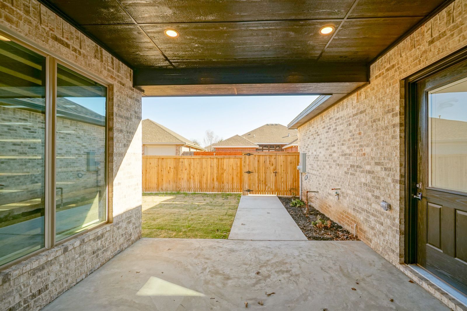 A brick house with a wooden fence in the backyard