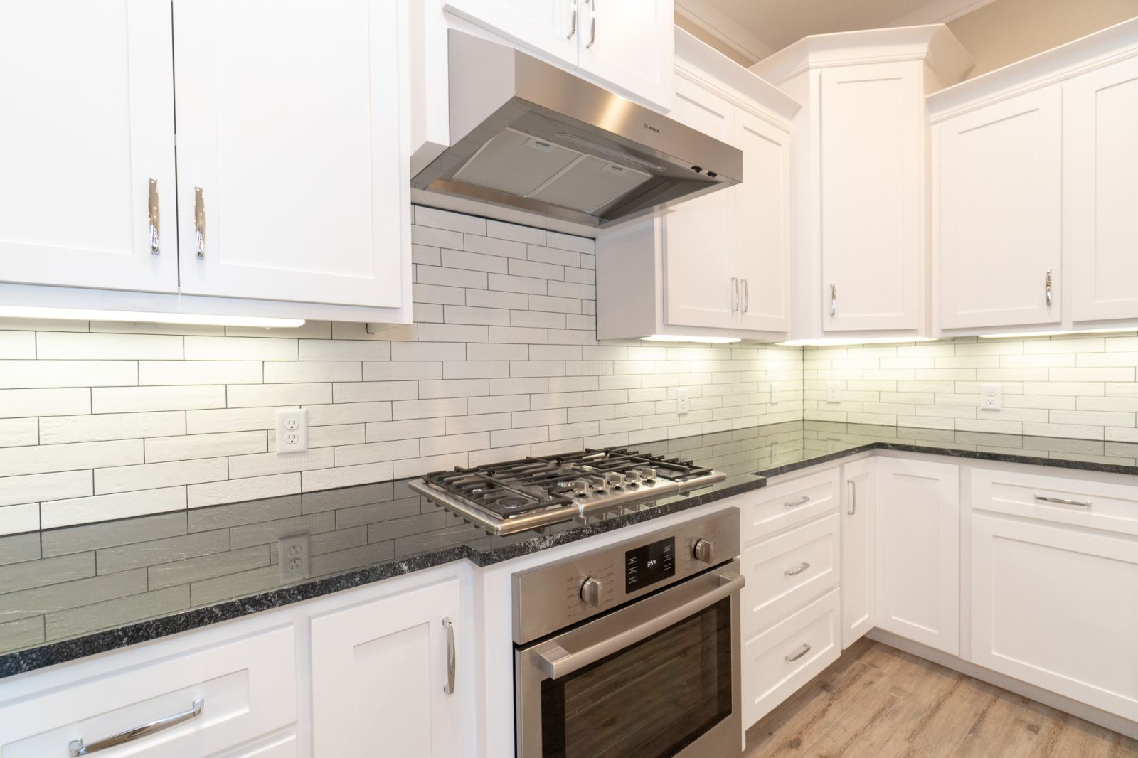 A kitchen with stainless steel appliances and white cabinets