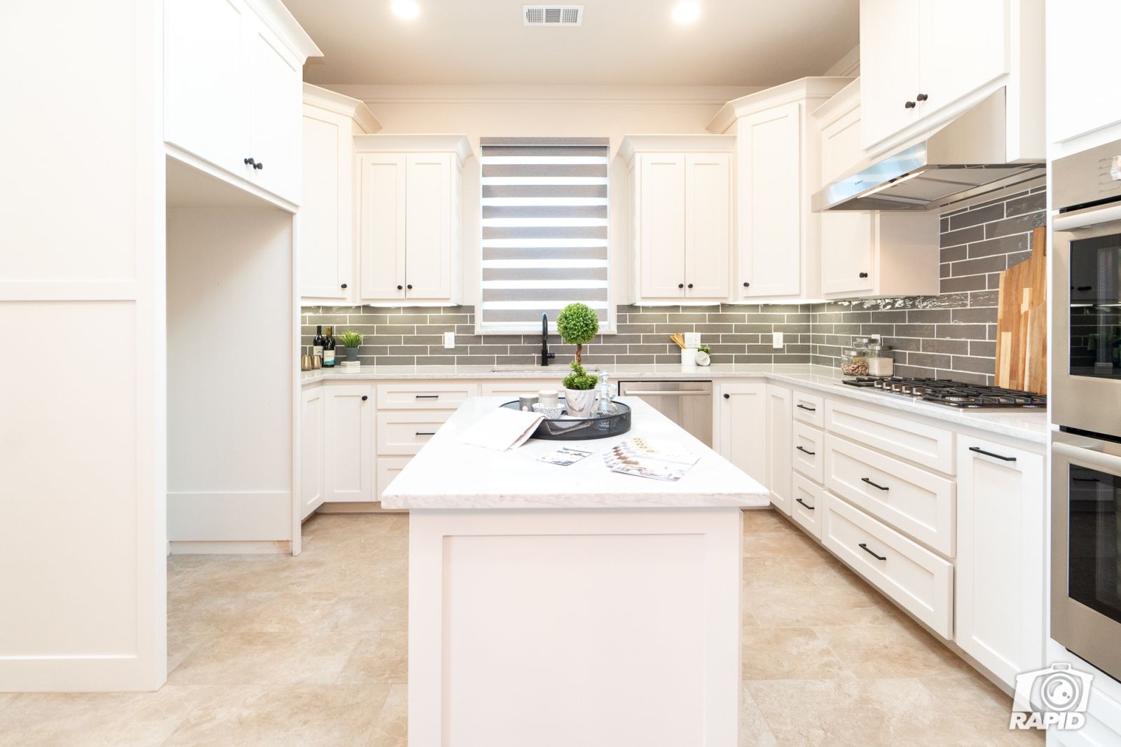 A kitchen with white cabinets and stainless steel appliances