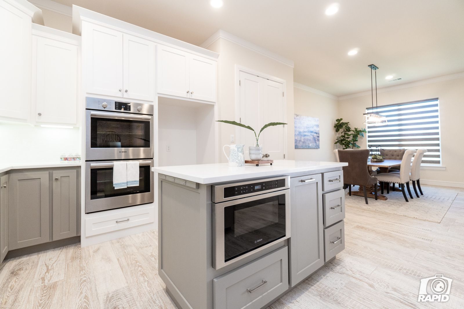 A kitchen with white cabinets and stainless steel appliances