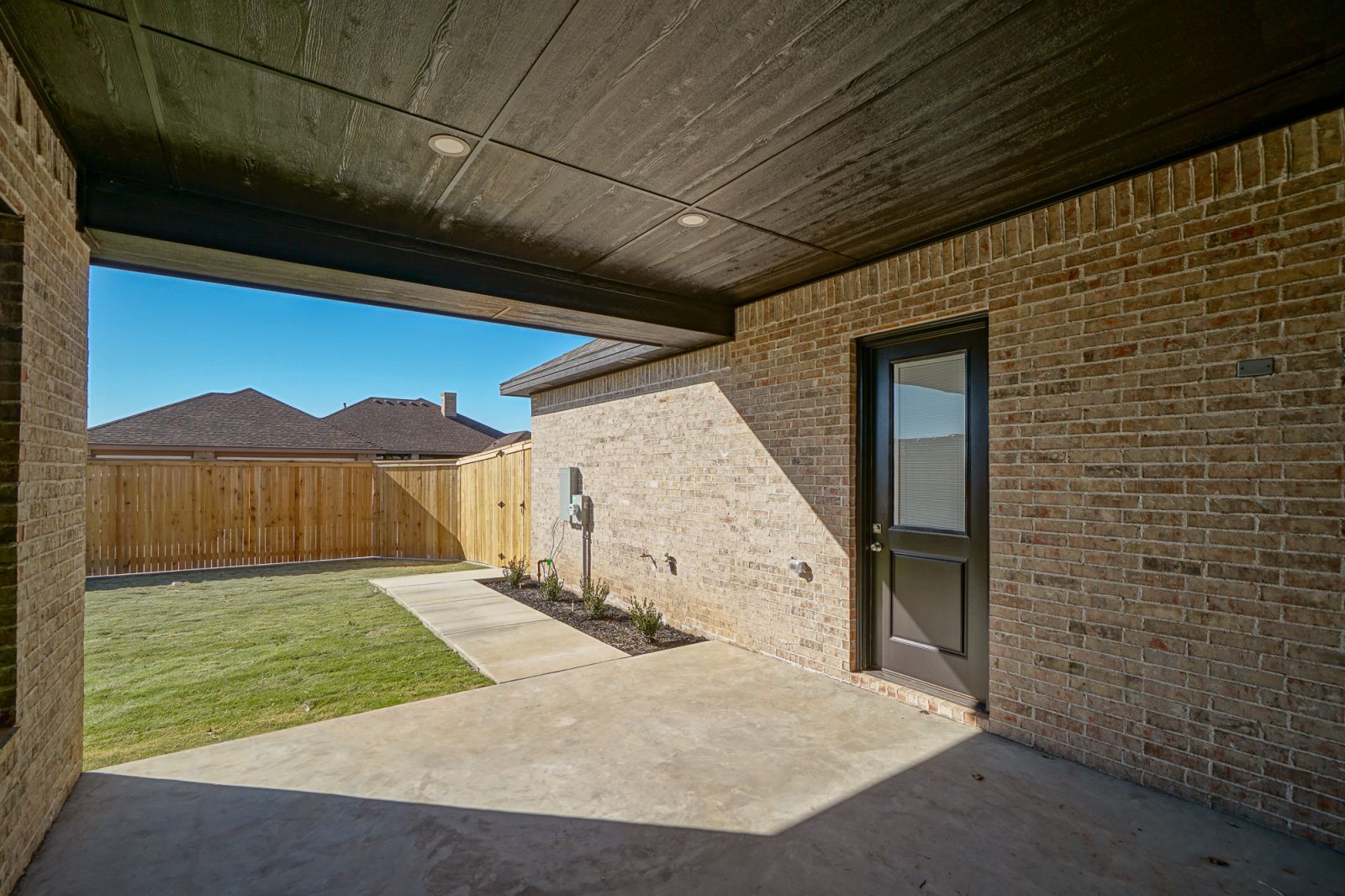 A brick house with a black door and a wooden fence