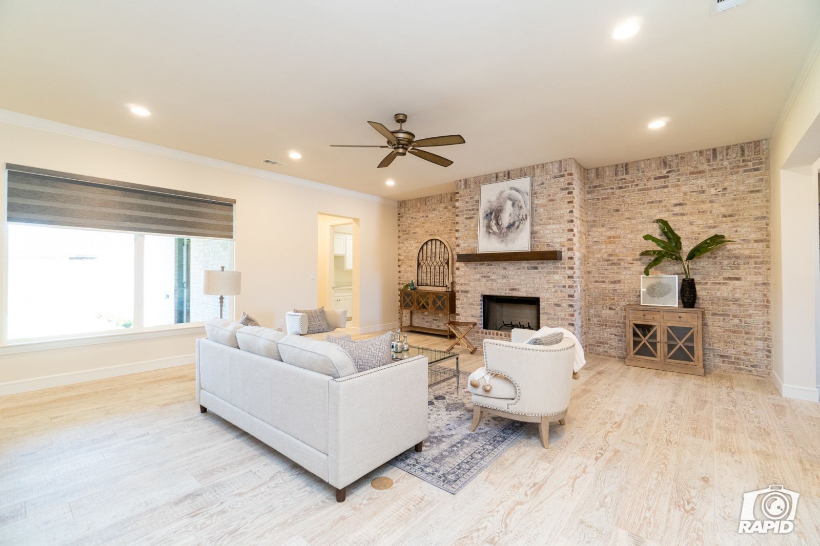 A living room with a fireplace and a ceiling fan