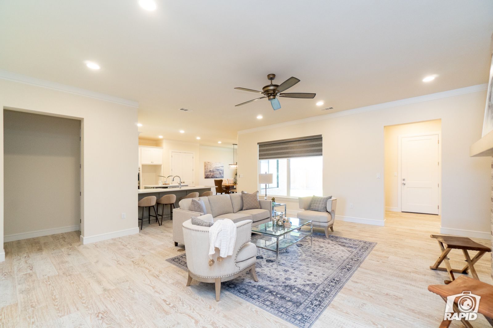 A living room with a ceiling fan and a rug