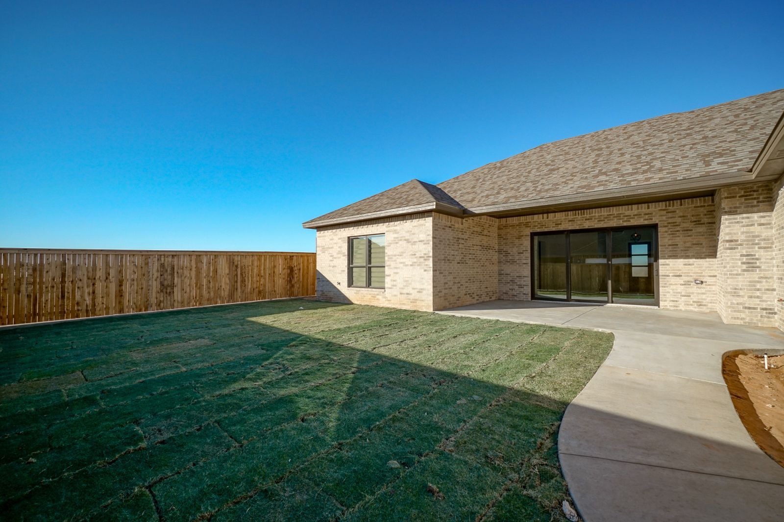 A brick house with a large lawn in front of it