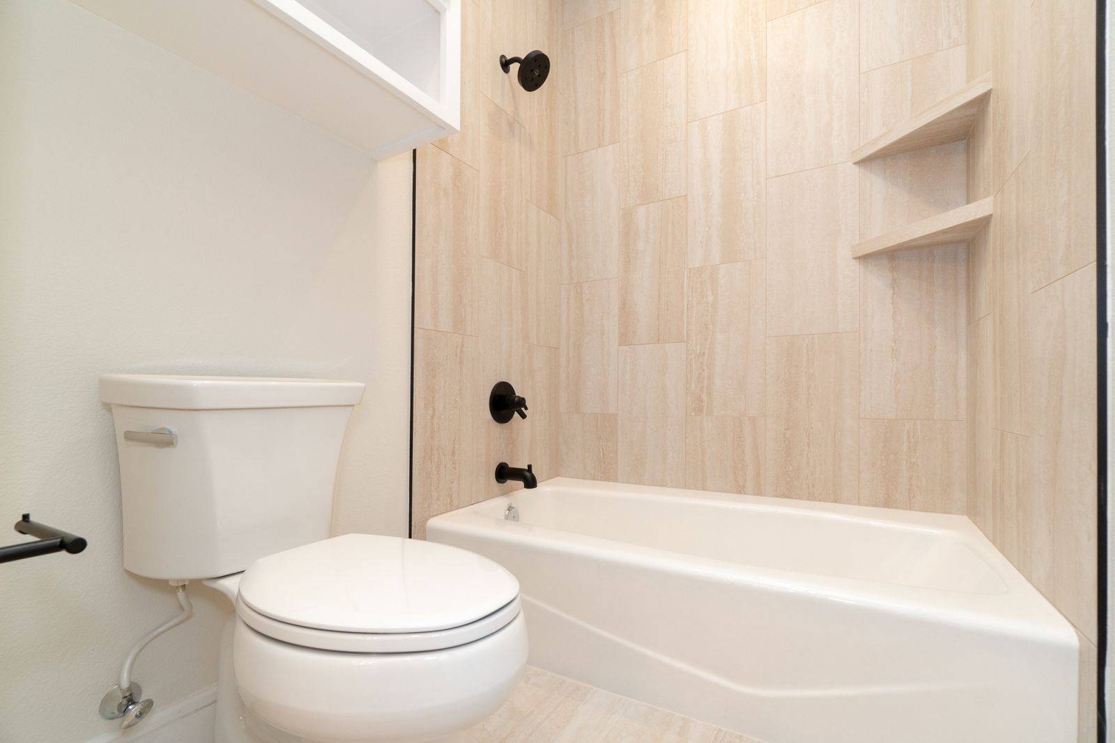 A bathroom with a toilet , bathtub and shower.