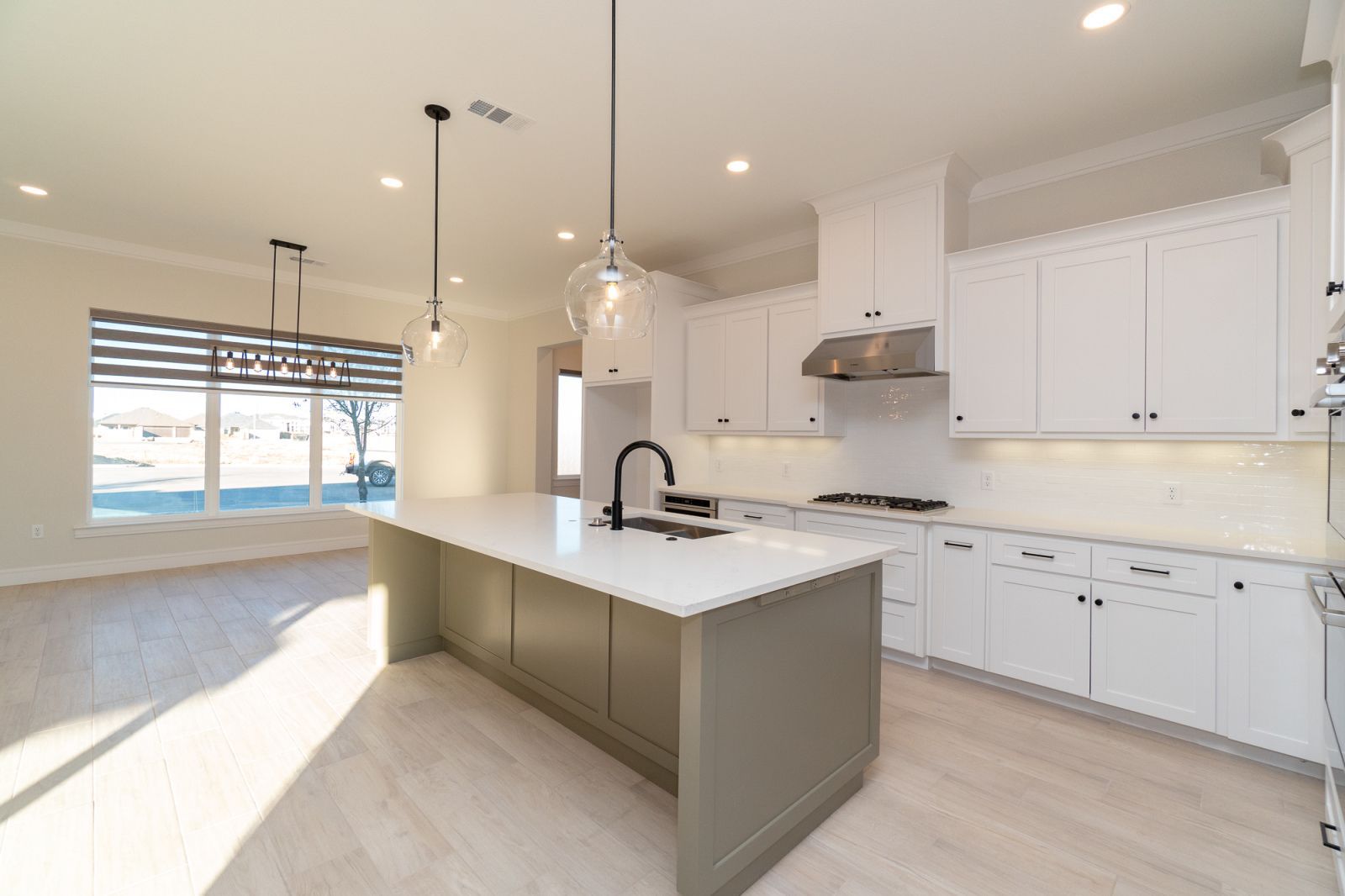 An empty kitchen with white cabinets and a large island