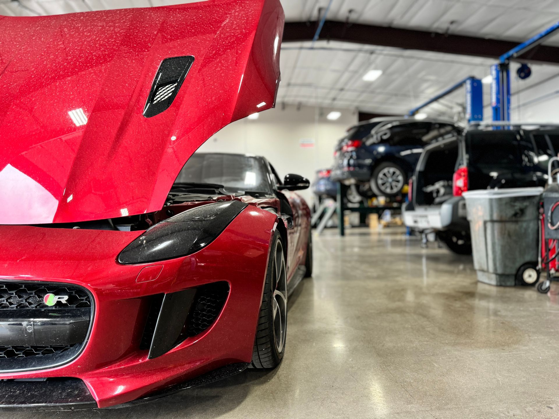 Red Jaguar sports car with its hood up | PPR Automotive