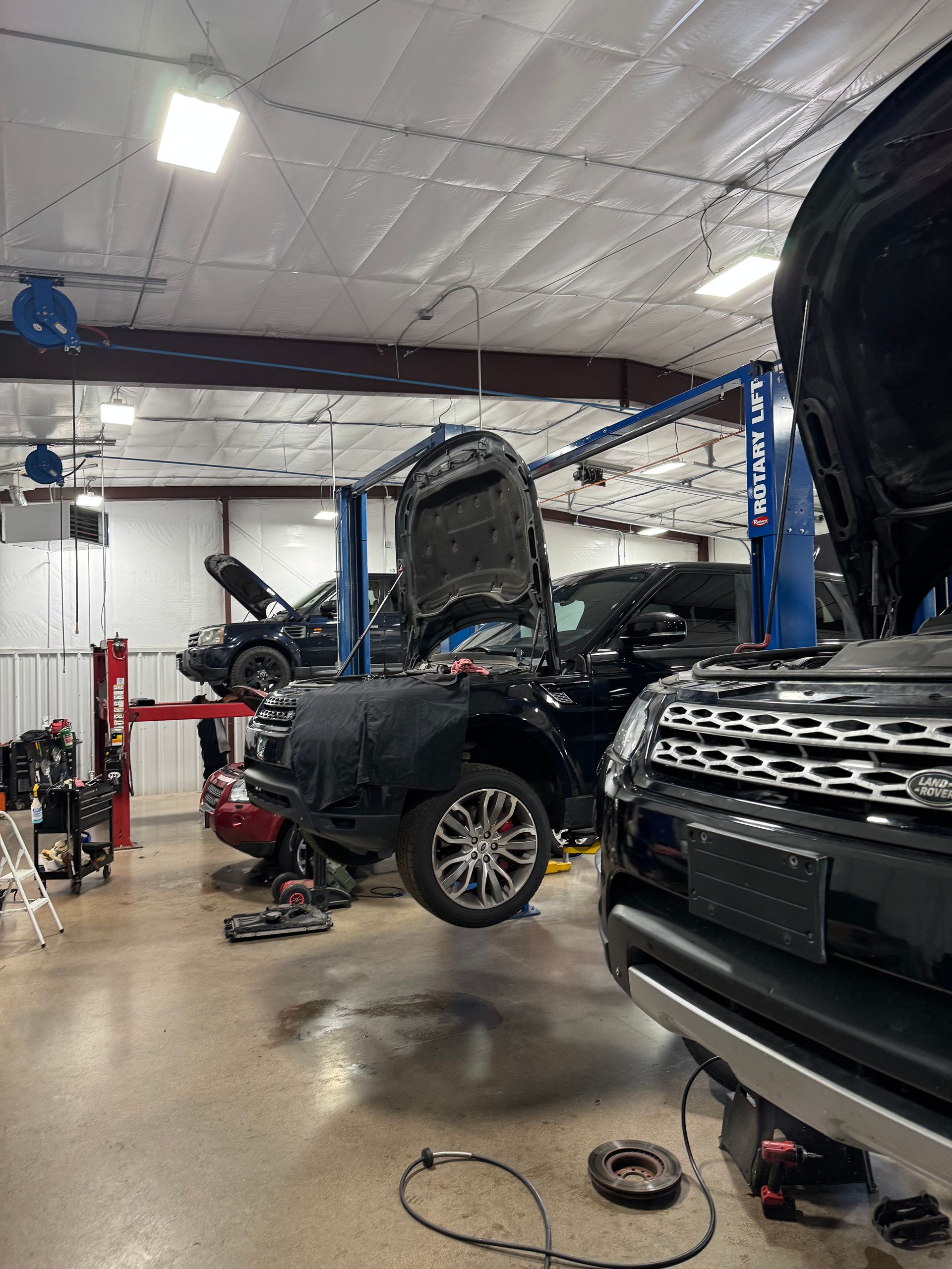 Cars in a garage being repaired with their hoods open | PPR Automotive