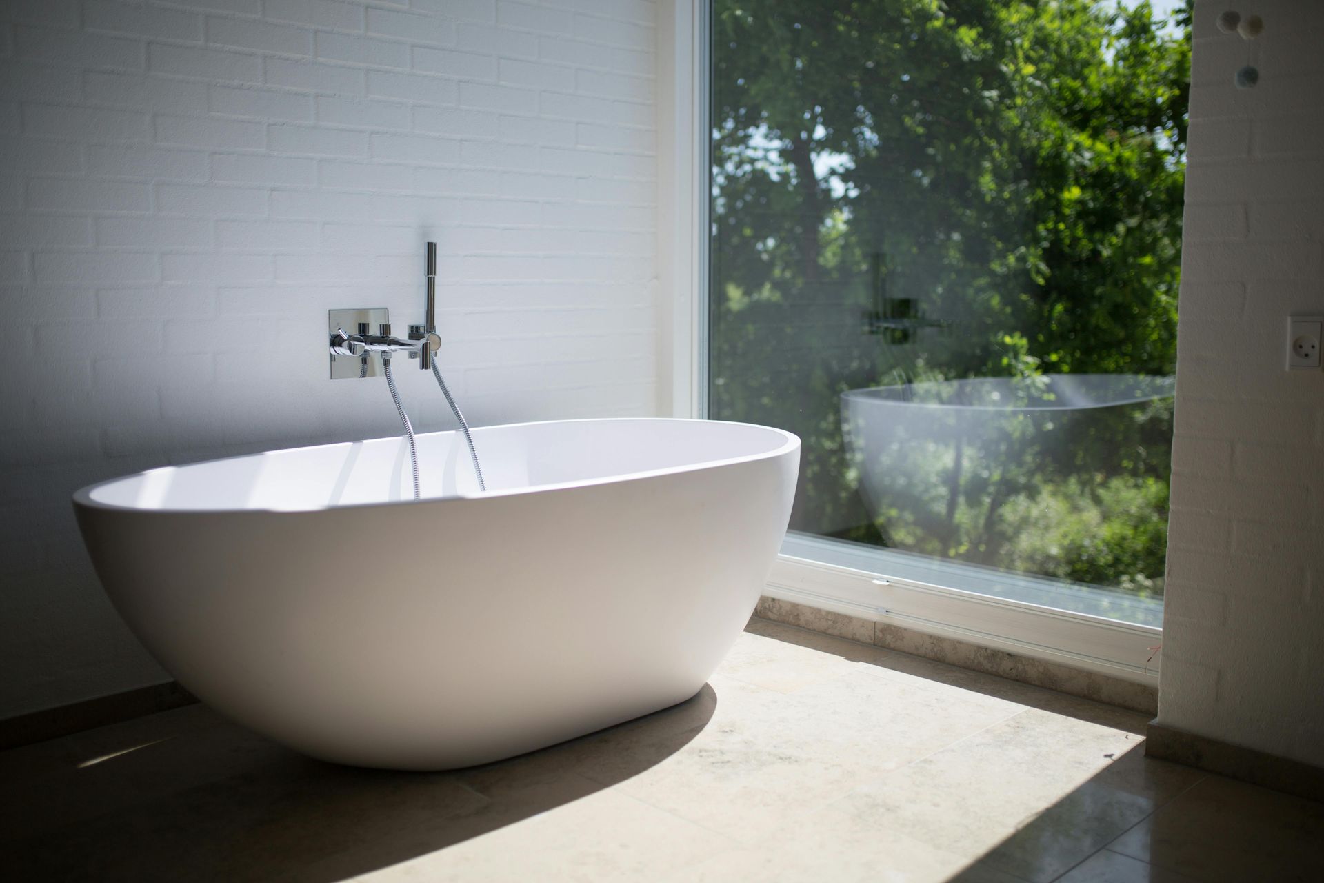 A bathtub is sitting in a bathroom next to a window.