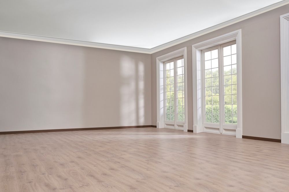 An empty room with a wooden floor and a lot of windows.