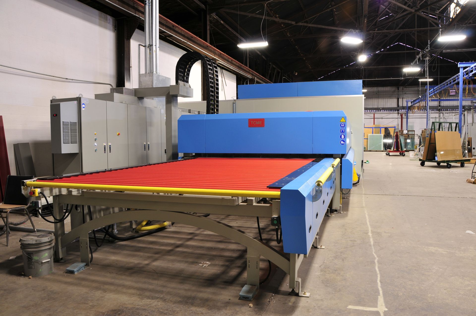 Large industrial machine with red surface, in a factory setting.