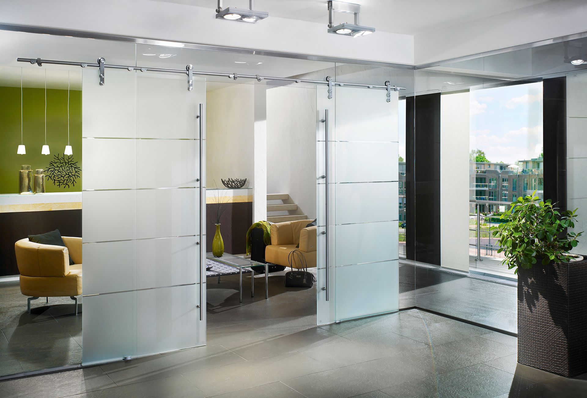Modern office space with frosted glass sliding doors, open to a room with seating.