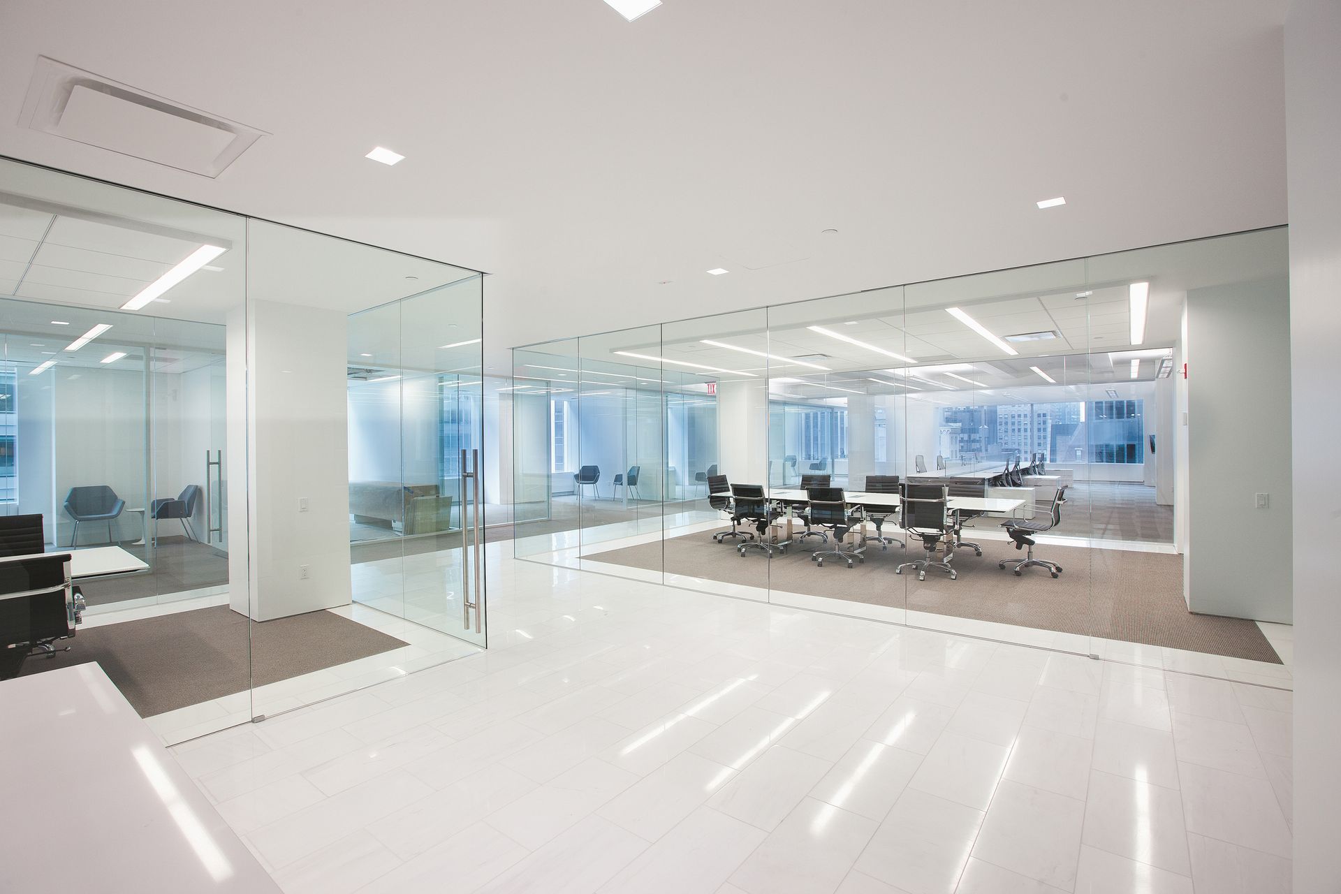 Modern office interior with glass walls, white floor, and a conference table.