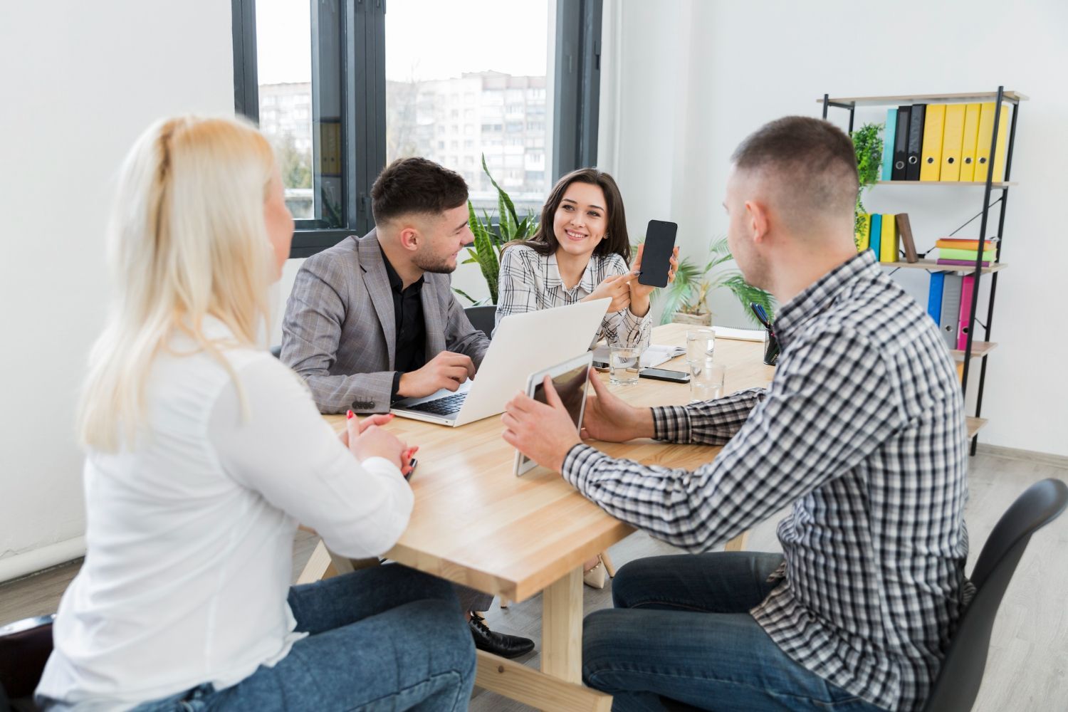 A group of people are sitting around a table having a meeting.