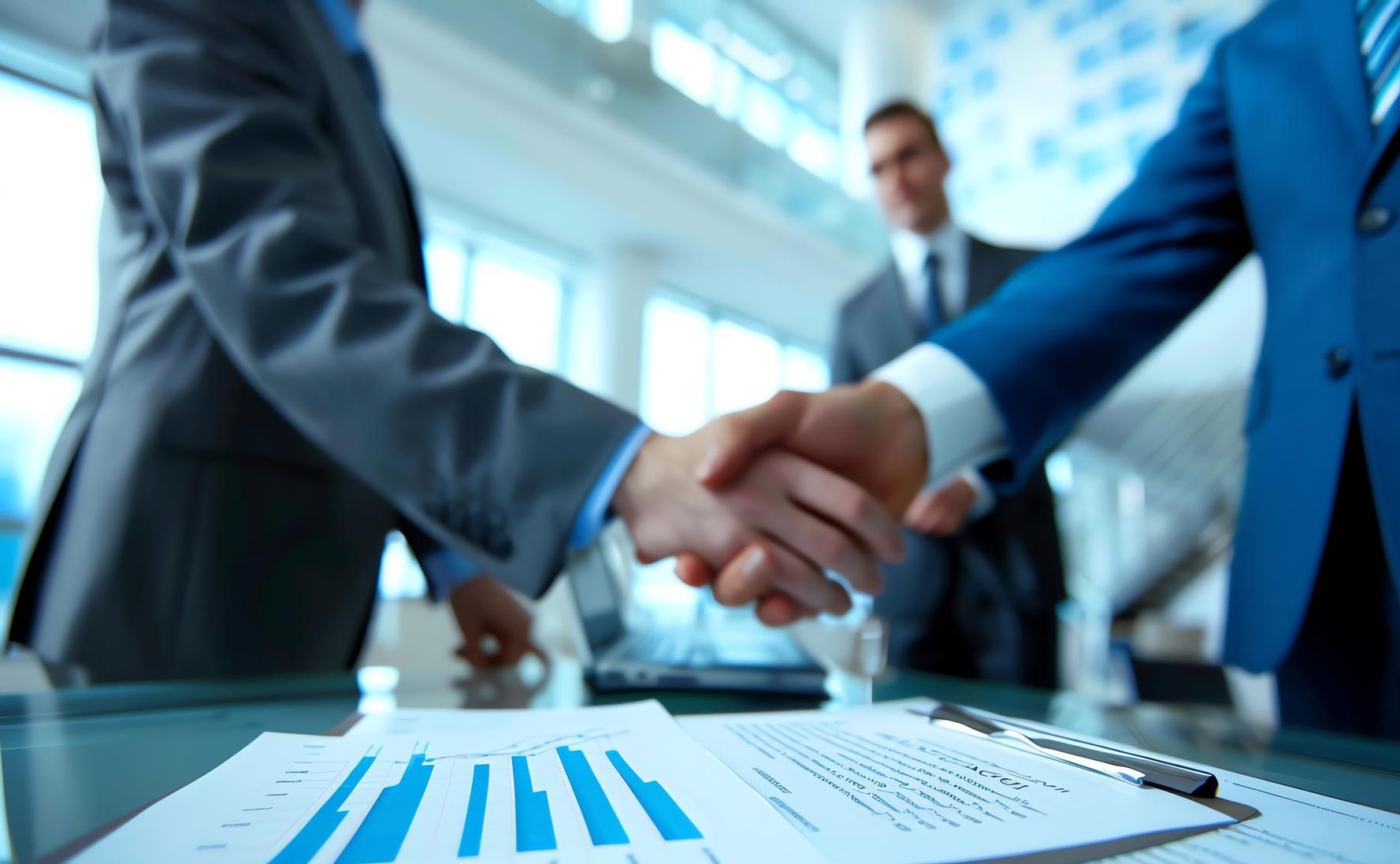 A group of business people are shaking hands over a table.