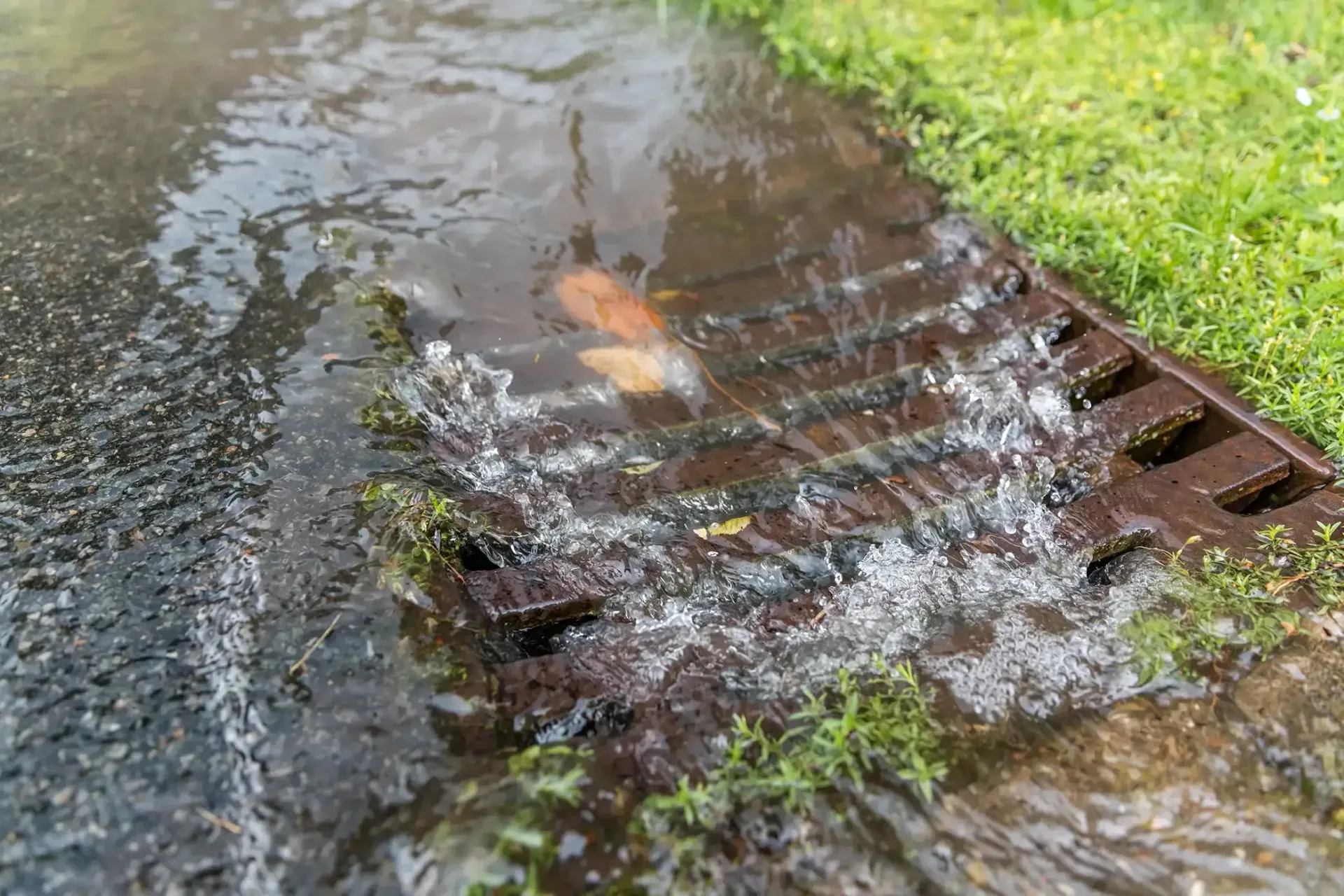 A close-up of a drain with water coming out of it.