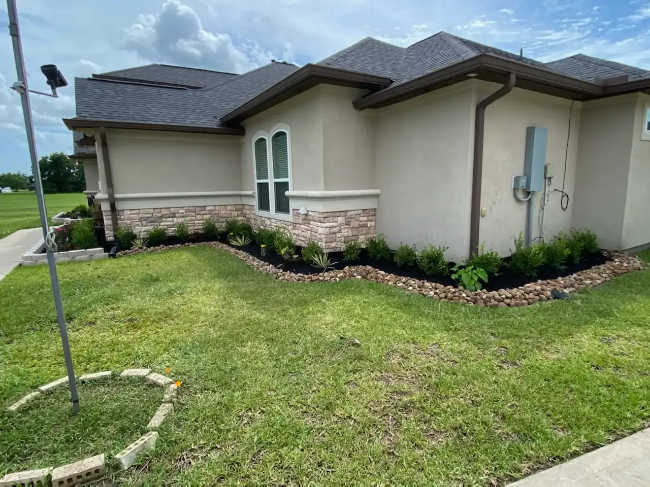 A house with a lush green lawn in front of it.