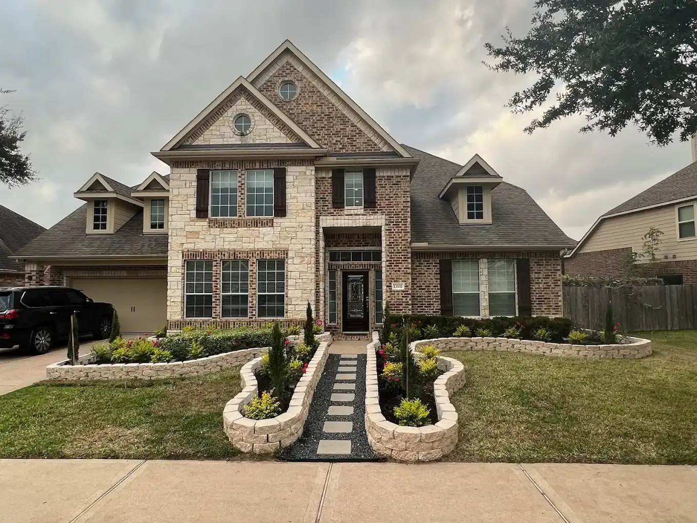 A large brick house with a car parked in front of it