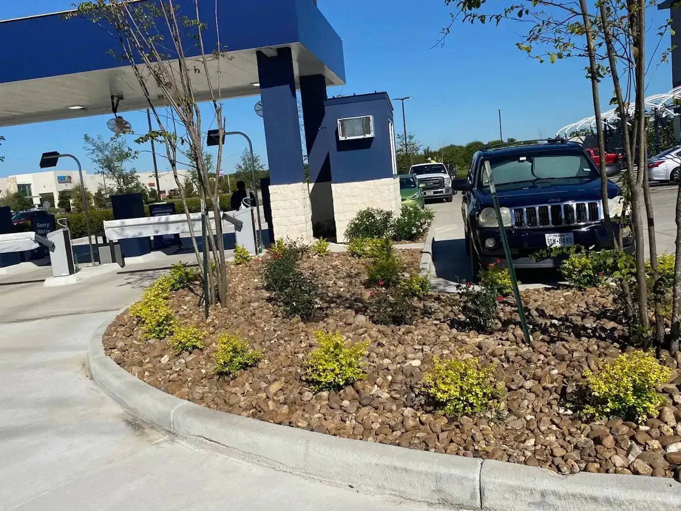 A black jeep is parked in front of a gas station