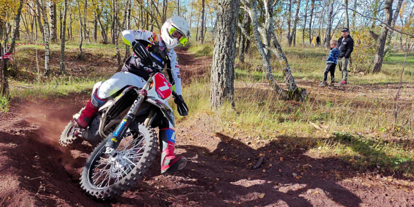 Off-road motorcyclist riding on wooded Texas trail.