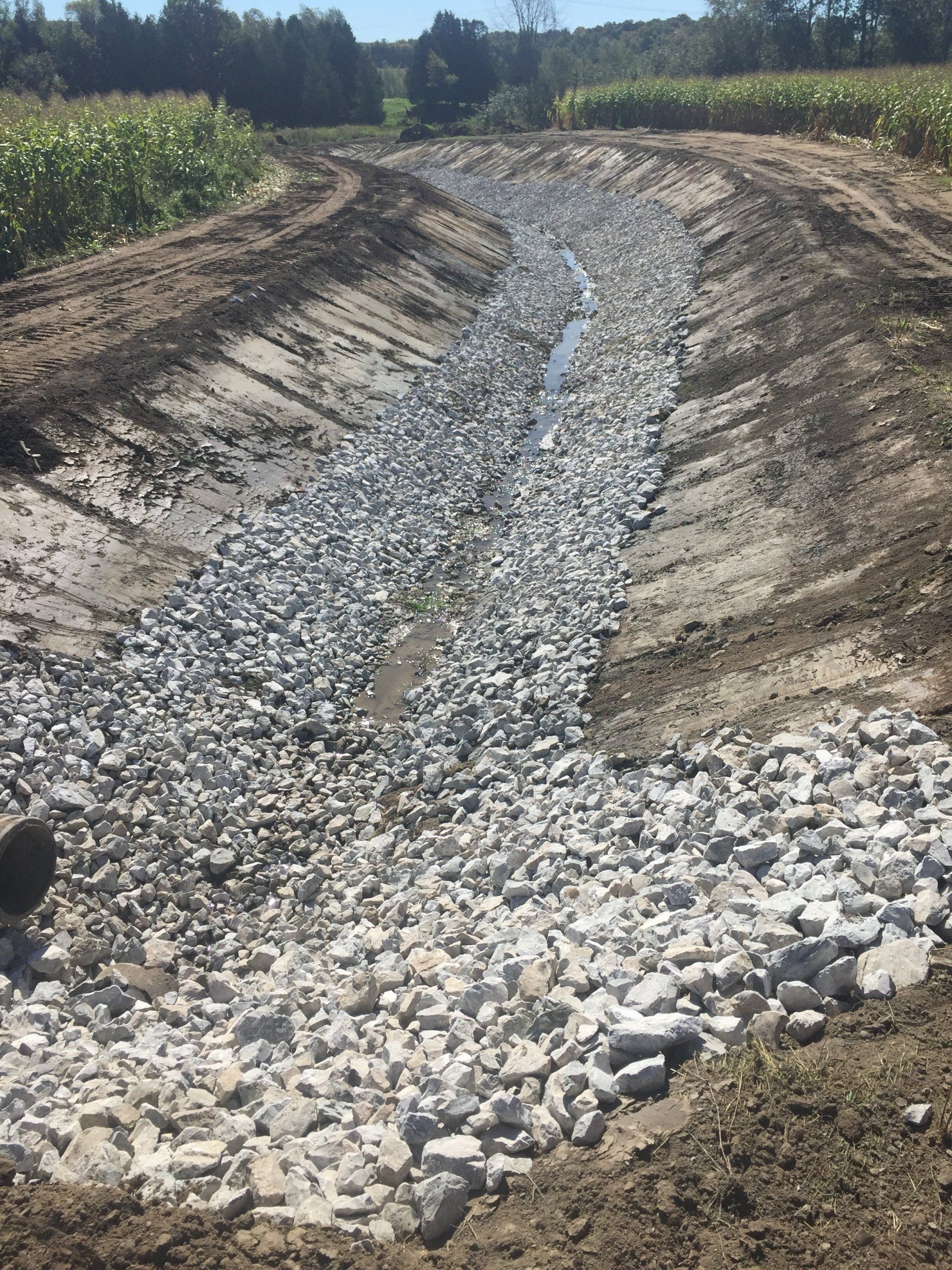 Un chemin de terre traversé par un ruisseau