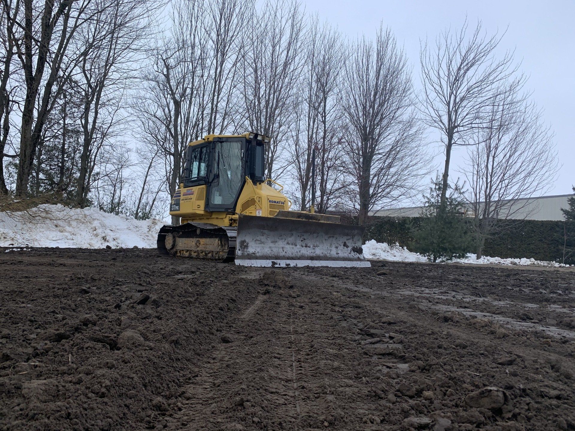 Un bulldozer traverse un champ boueux.