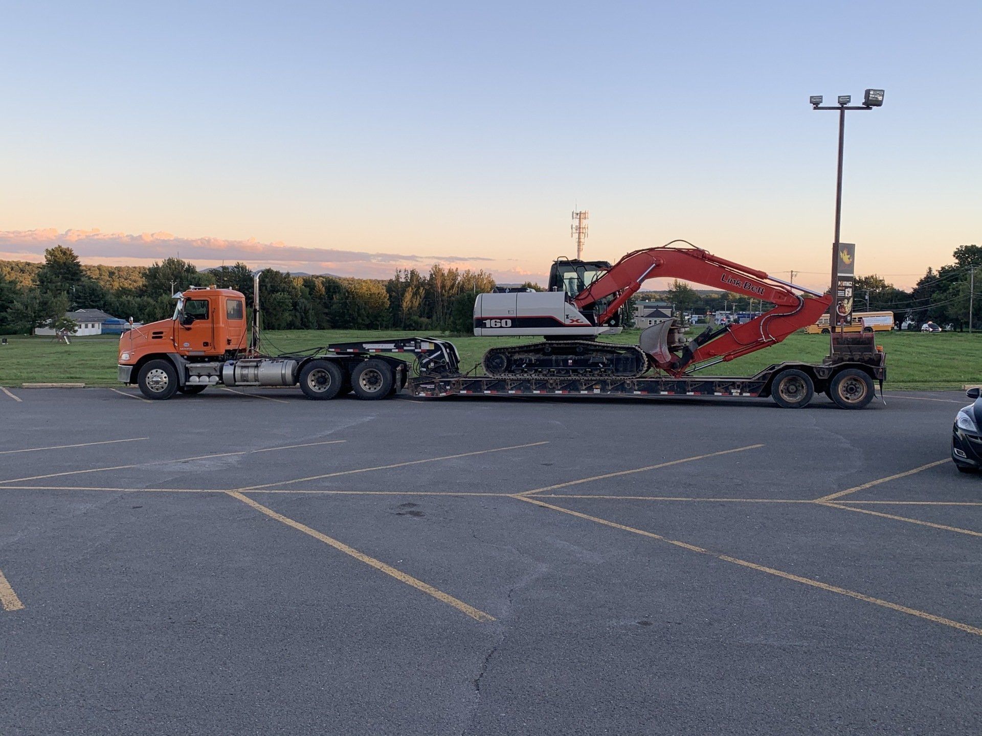 Un semi-remorque transporte une grosse pelle sur une remorque à plateau.