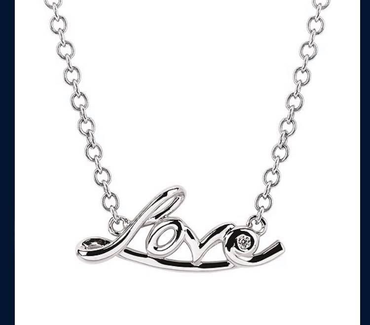 A silver necklace with the word love on it