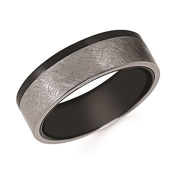 A wedding ring and engagement ring are stacked on top of each other on a white background.