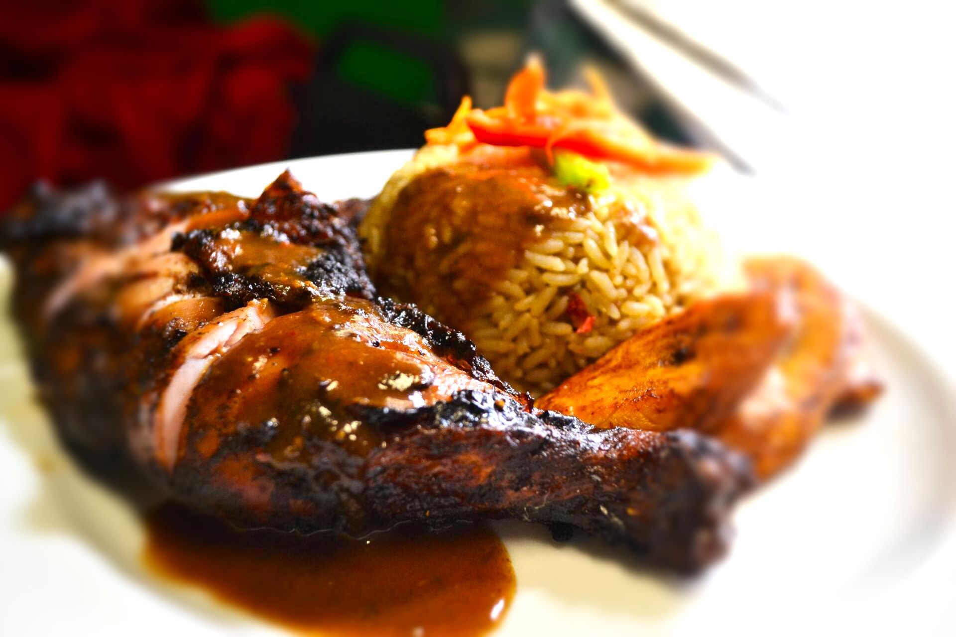 A white plate topped with a piece of meat and rice