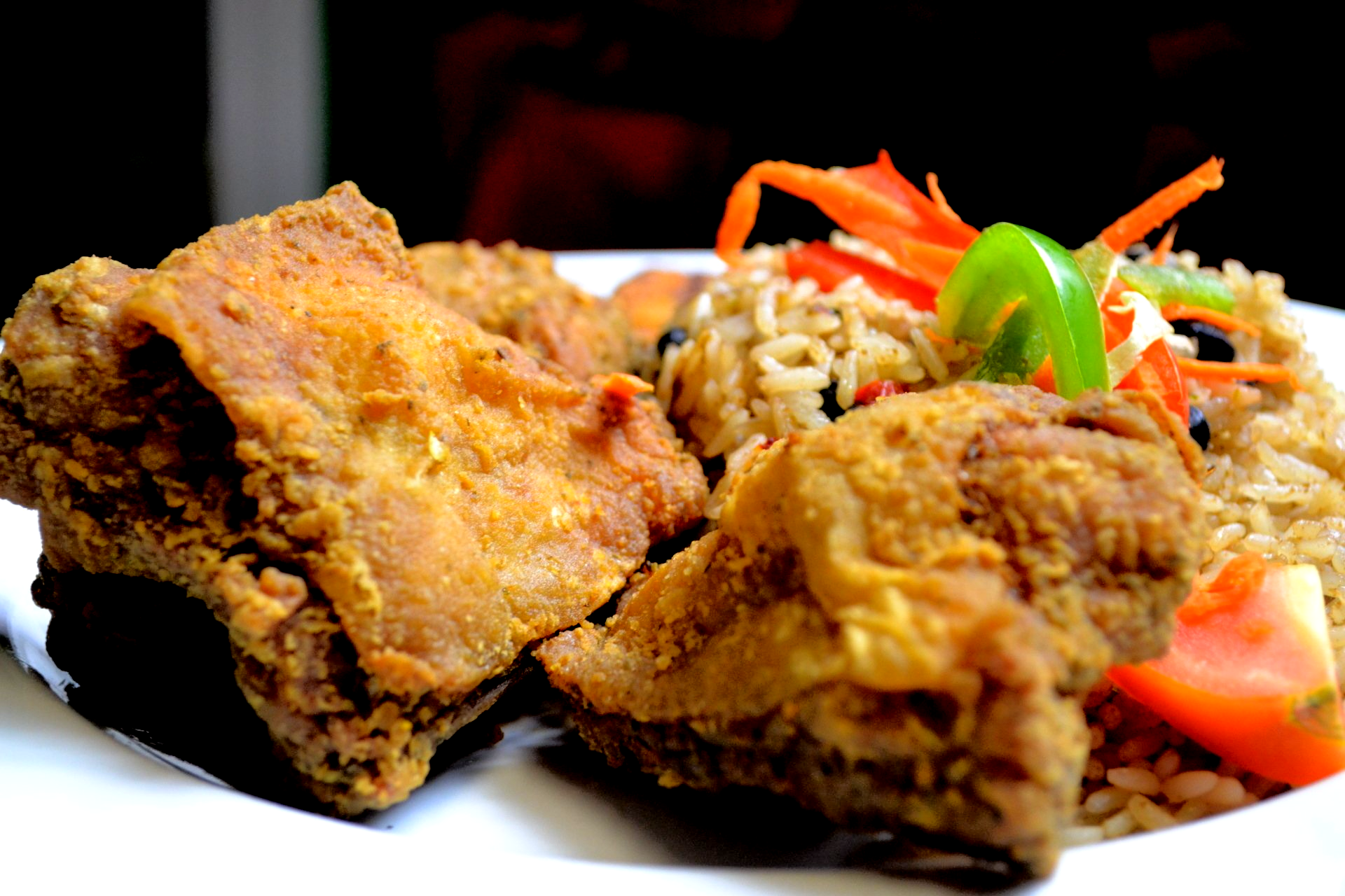 A white plate topped with fried chicken and rice