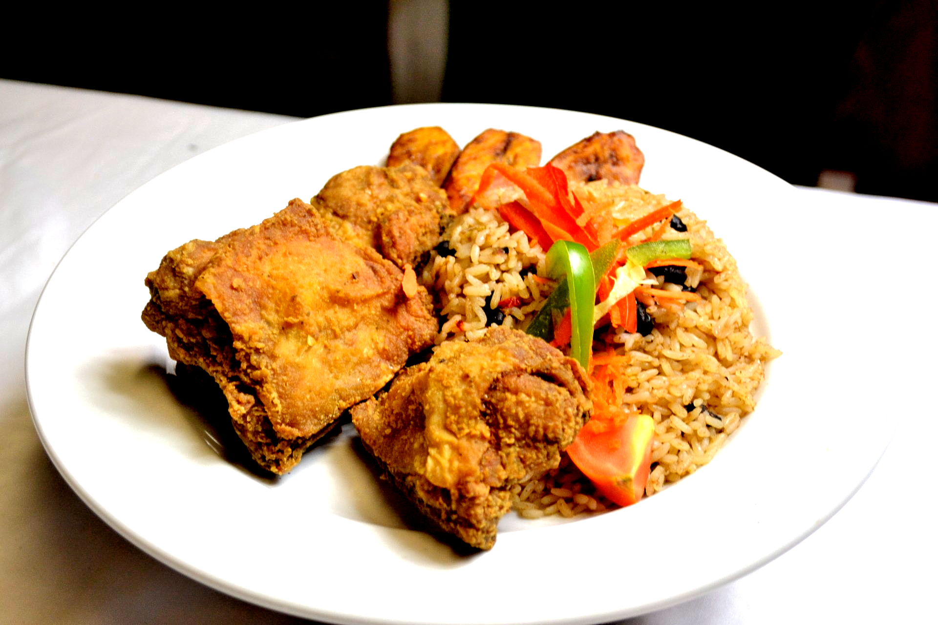 A white plate topped with fried chicken and rice