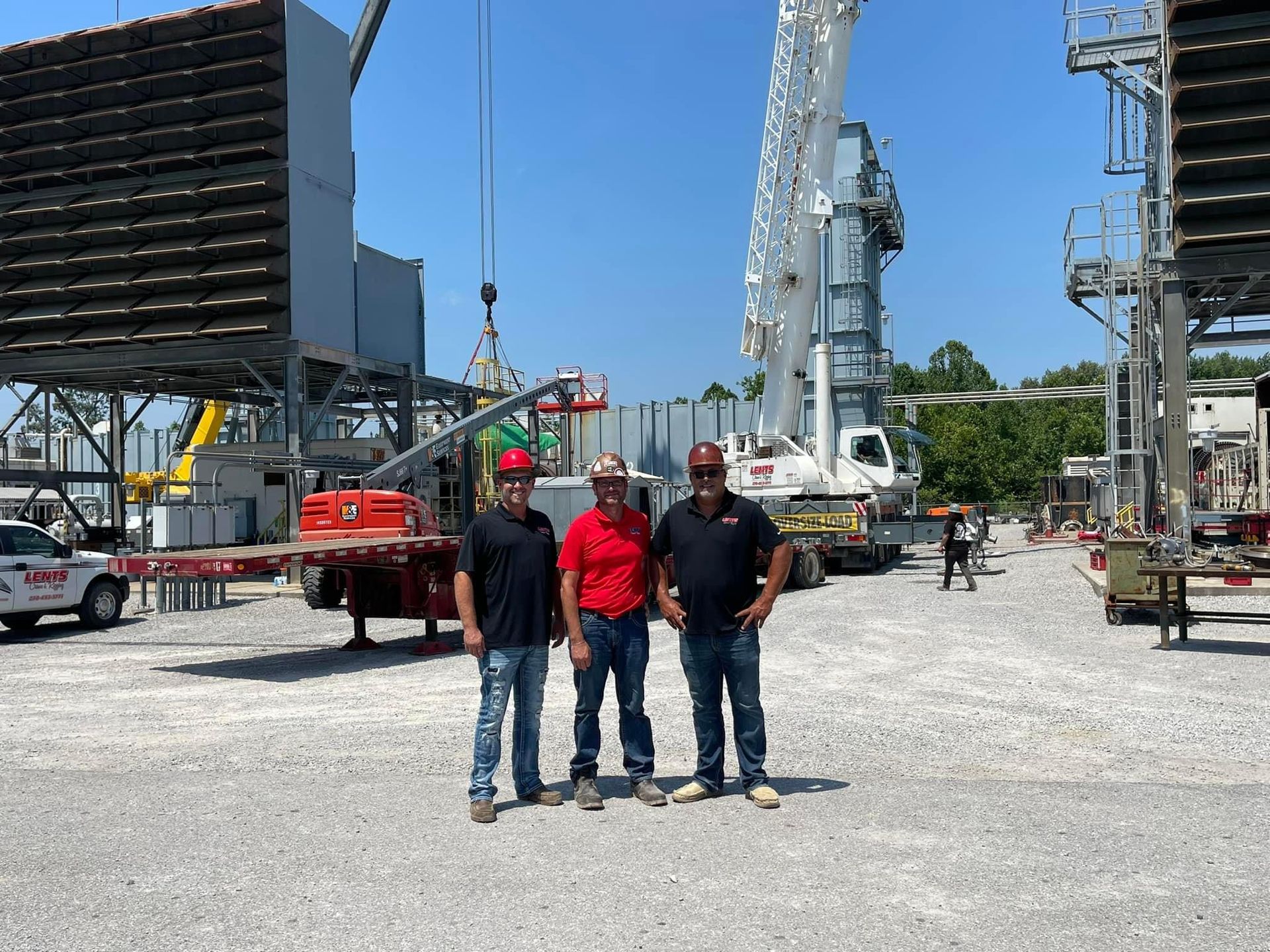 Three men are standing in front of a construction site.