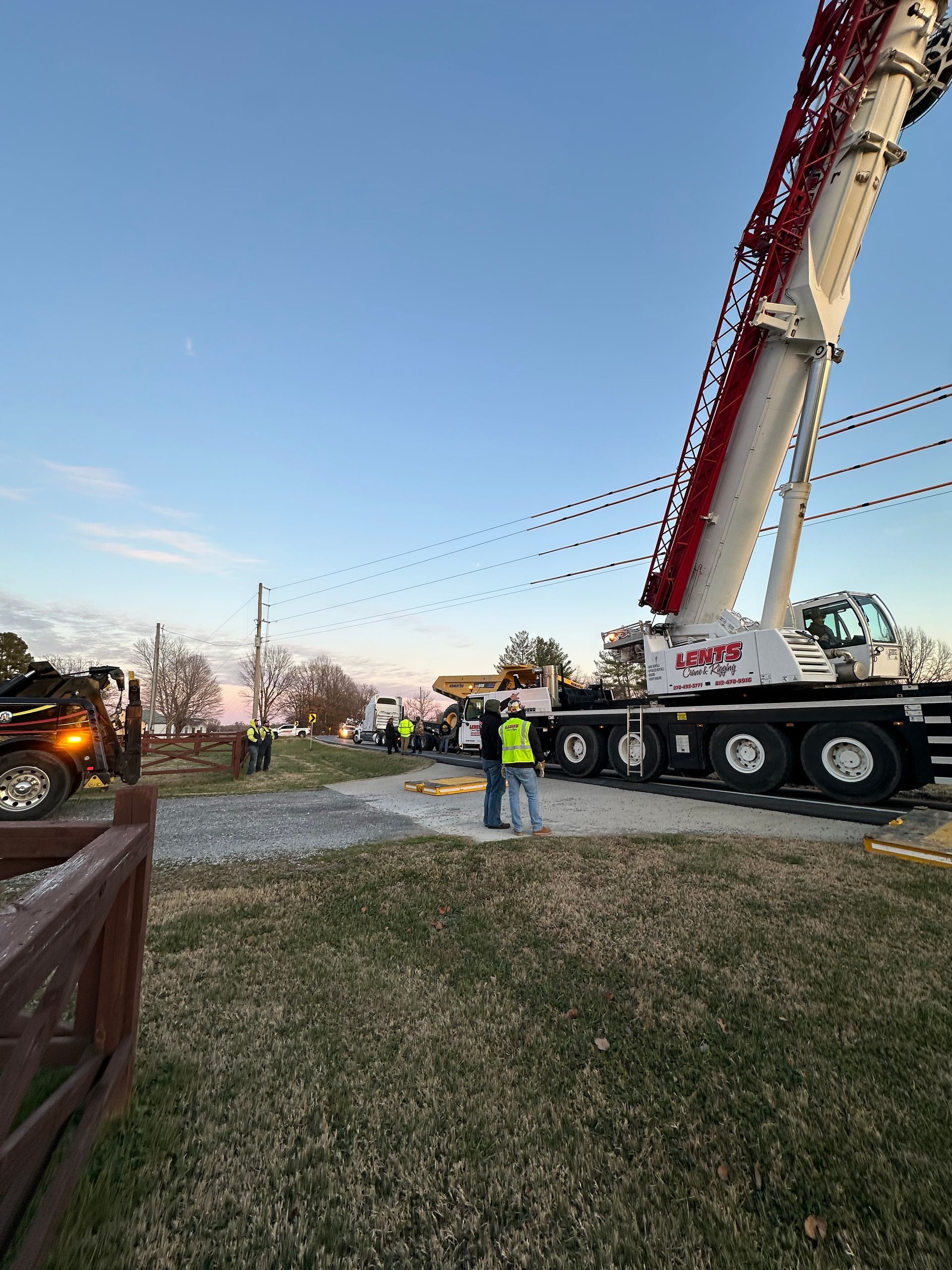 A large crane is sitting on top of a truck in a field.