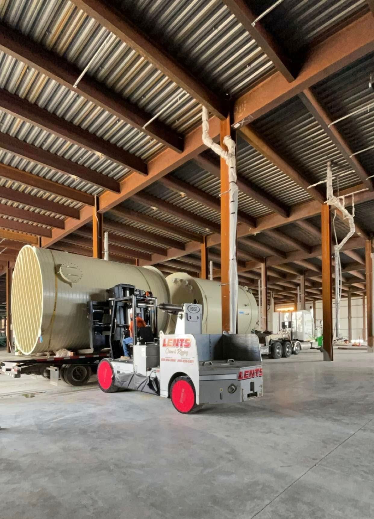 A forklift in a large warehouse with the number 1 on it